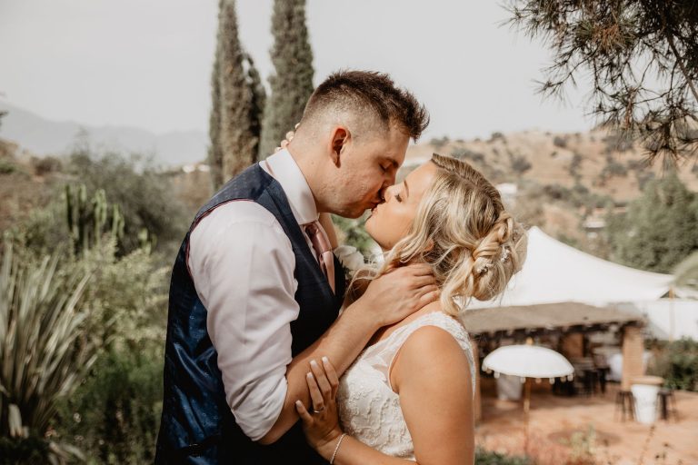 A newlywed couple share a kiss at the luxury wedding venue, Finca Santa Fe.